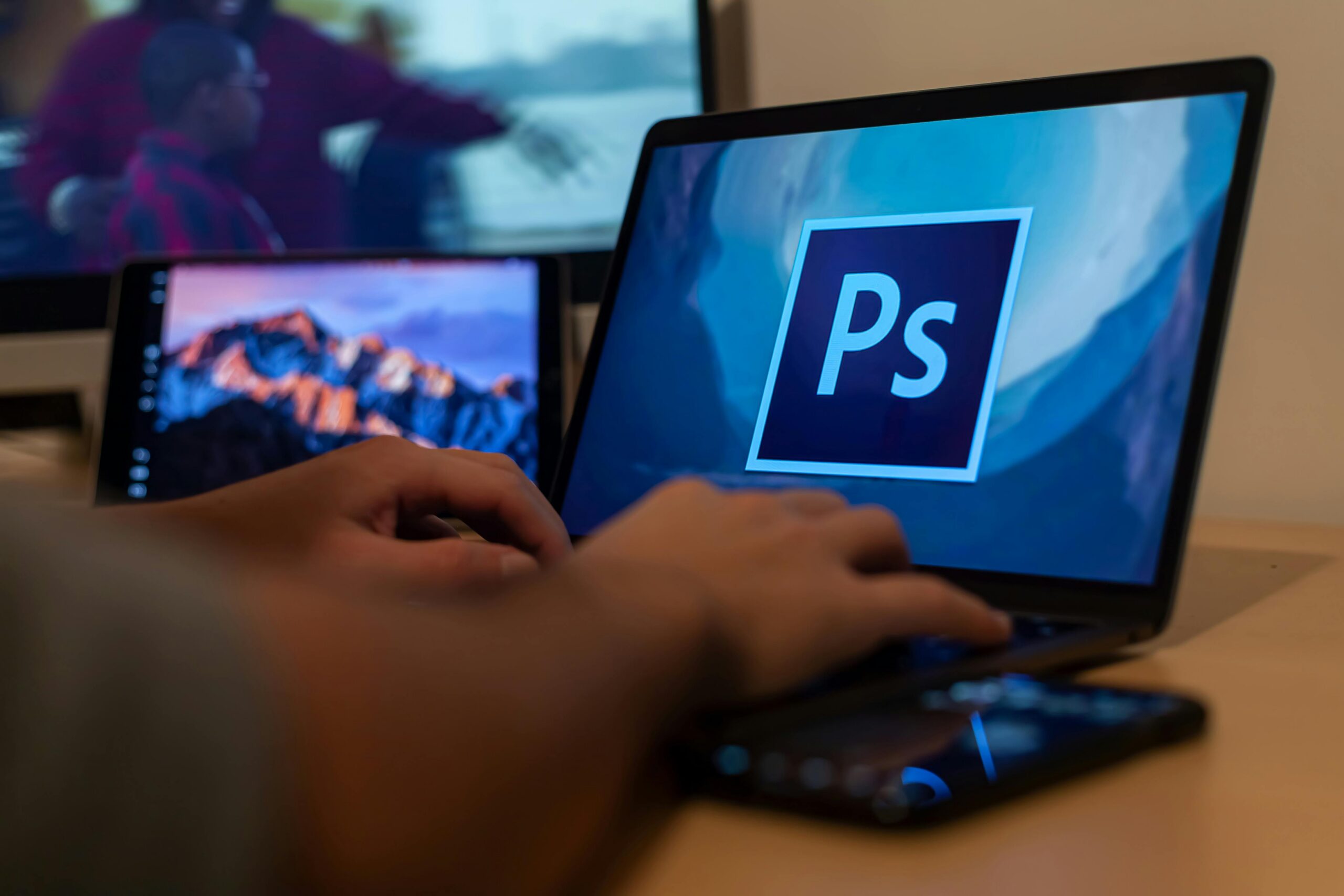 curriculum vitae Hands working with Photoshop on a laptop, showcasing digital photo editing from home.